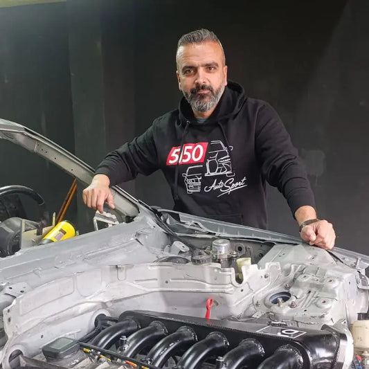 Man wearing black 5150 AutoSport BMW hoodie, featuring BMW E30 and BMW G80 silhouettes.